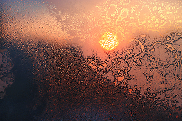 Image showing Ice patterns, water drops and sunlight on a window glass