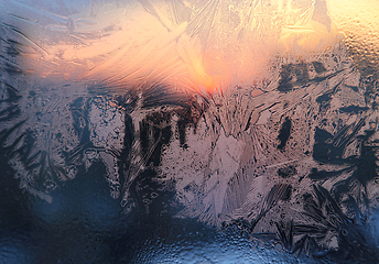 Image showing Ice patterns, water drops and sunlight on a window glass