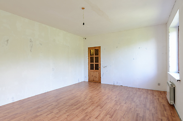 Image showing A fragment of the interior of a spacious room with a fine finish, view of the front door