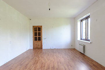 Image showing Fragment of a room with a fine finish, view of the front door, there is one window in the room