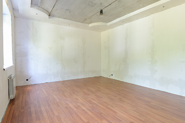 Image showing Interior of an empty room during renovation with plastered walls and laminate flooring