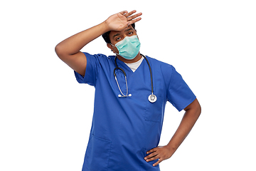 Image showing tired indian male doctor in blue uniform and mask