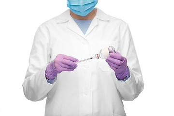 Image showing close up of doctor in mask with drug and syringe