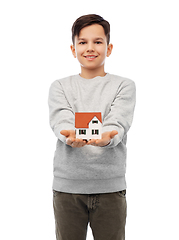 Image showing smiling boy holding house model