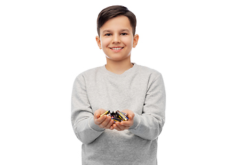 Image showing smiling boy holding pile of alkaline batteries