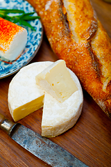 Image showing French cheese and fresh  baguette on a wood cutter