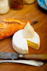 Image showing French cheese and fresh  baguette on a wood cutter