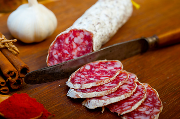 Image showing traditional Italian salame cured sausage sliced on a wood board