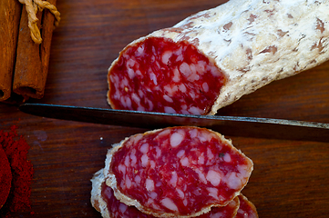 Image showing traditional Italian salame cured sausage sliced on a wood board