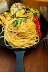 Image showing italian spaghetti pasta with zucchini sauce on iron skillet