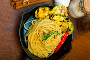 Image showing italian spaghetti pasta with zucchini sauce on iron skillet