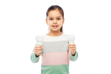 Image showing smiling girl comparing different light bulbs