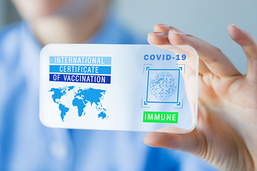 Image showing hand with certificate of vaccination on smartphone