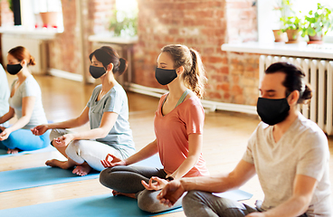 Image showing group of people in masks doing yoga at studio