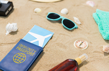 Image showing travel tickets, camera and hat on beach sand