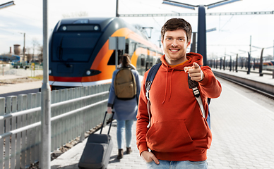 Image showing smiling man with backpack traveling by train