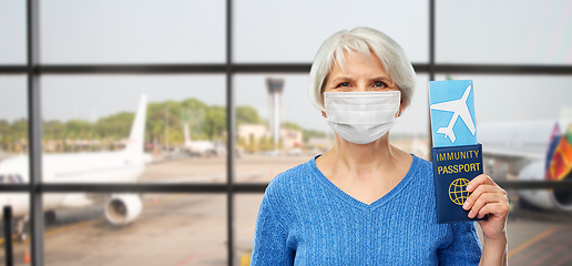 Image showing old woman in mask with immune passport and ticket