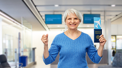 Image showing senior woman with immunity passport and air ticket