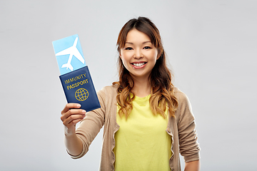 Image showing asian woman with air ticket and immunity passport