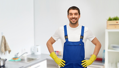 Image showing happy male worker or cleaner in gloves at kitchen