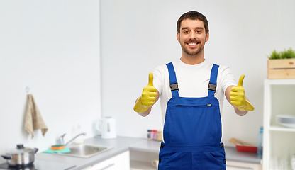 Image showing happy male worker or cleaner in gloves at kitchen