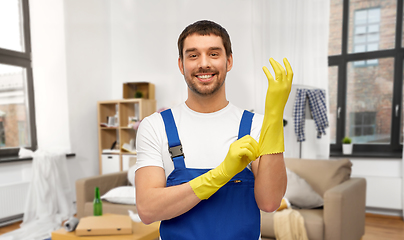 Image showing male worker or cleaner wearing gloves at home