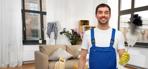 Image showing happy male cleaner with duster cleaning home room