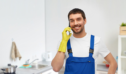 Image showing male worker or cleaner calling on phone at kitchen