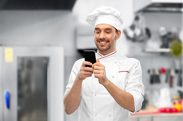 Image showing happy smiling male chef with smartphone at kitchen