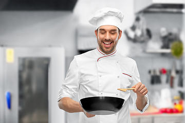 Image showing smiling male chef with frying pan cooking food