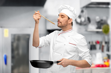 Image showing happy male chef with frying pan tasting food