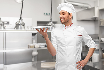 Image showing happy smiling male chef holding empty plate