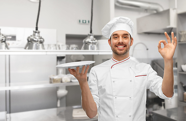 Image showing happy smiling male chef holding empty plate