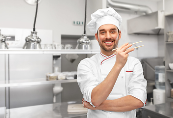 Image showing happy smiling male chef with chopsticks