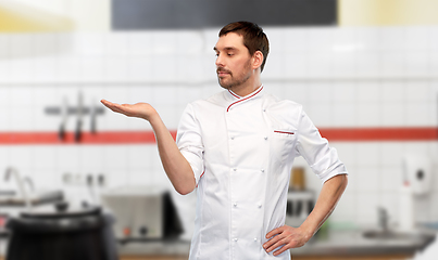 Image showing male chef holding something on hand