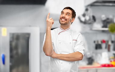 Image showing happy smiling male chef pointing finger up