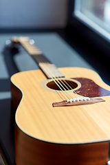 Image showing close up of acoustic guitar on window sill