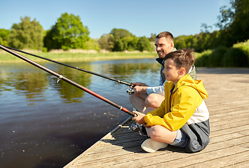 Image showing happy smiling father and son fishing on river