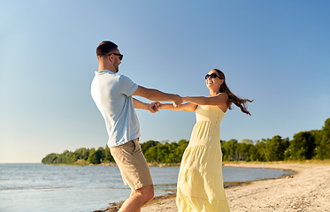 Image showing happy couple holding hands on summer beach