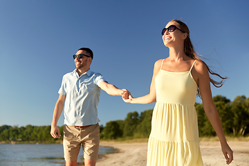 Image showing happy couple holding hands on summer beach