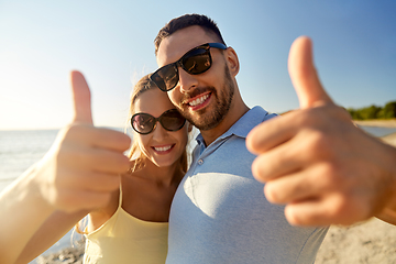 Image showing happy couple showing thumbs up on summer beach