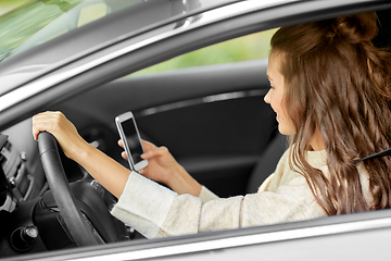 Image showing smiling woman or female driver driving car in city