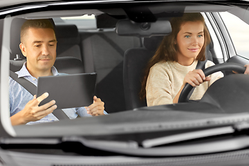 Image showing woman and driving school instructor talking in car