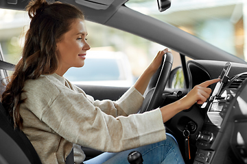 Image showing smiling woman or female driver driving car in city