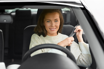 Image showing woman or female car driver fastening seat belt