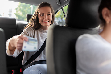 Image showing female passenger giving money to taxi car driver