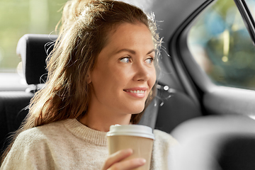 Image showing smiling woman or passenger drinking coffee in car