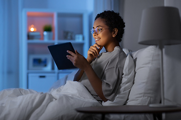 Image showing woman with tablet pc in bed at home at night