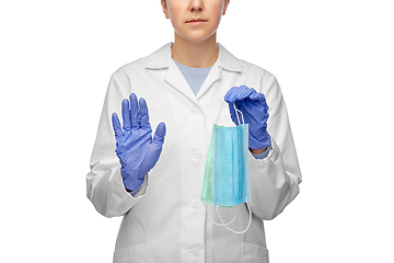 Image showing female doctor with two masks showing stop gesture