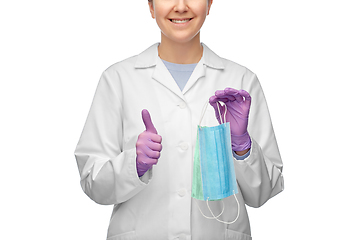 Image showing smiling doctor with two masks showing thumbs up